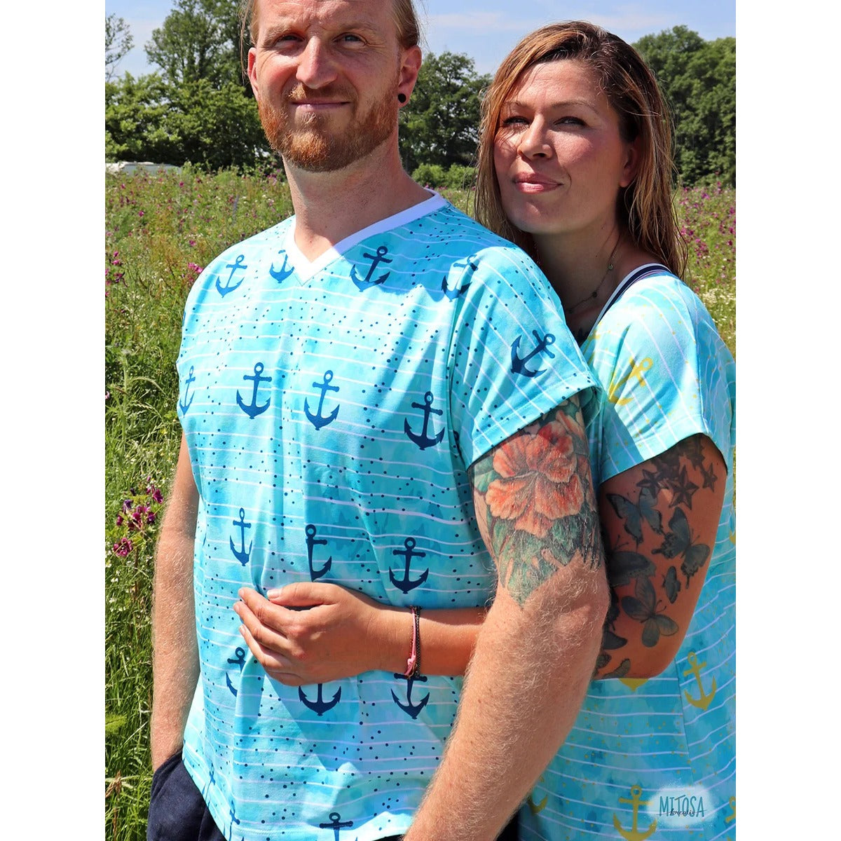 Paar im maritimen Partnerlook mit Family Shirt und V-Ausschnitt aus türkisem Anker-Stoff