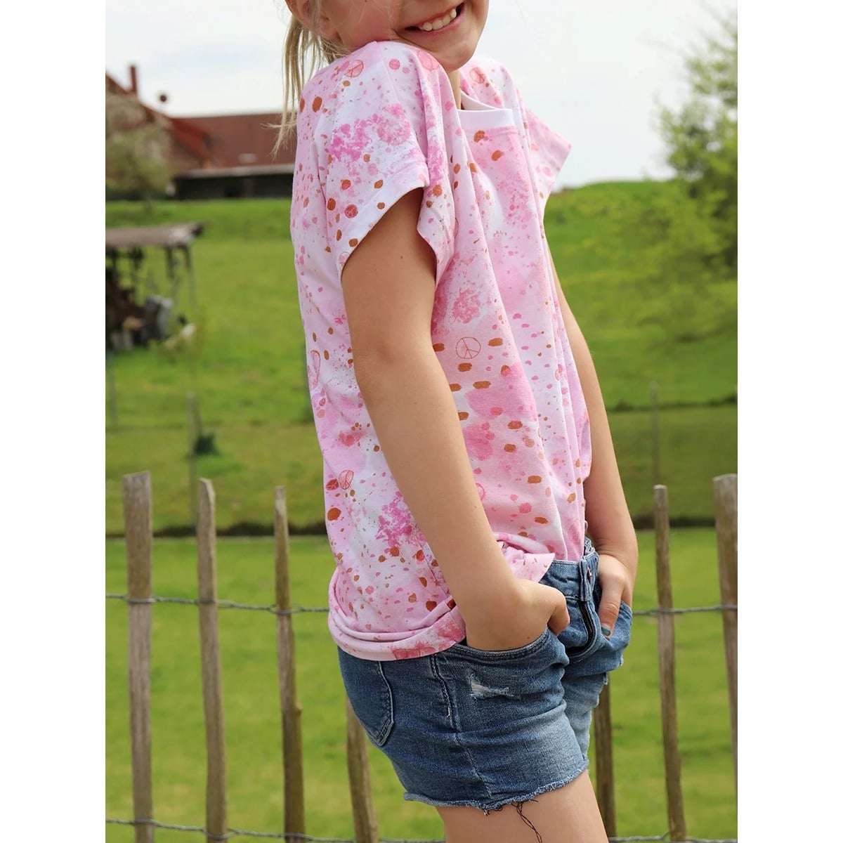 Mädchen im rosa Family Shirt Kids mit Batik-Klecks-Muster und Peace-Zeichen