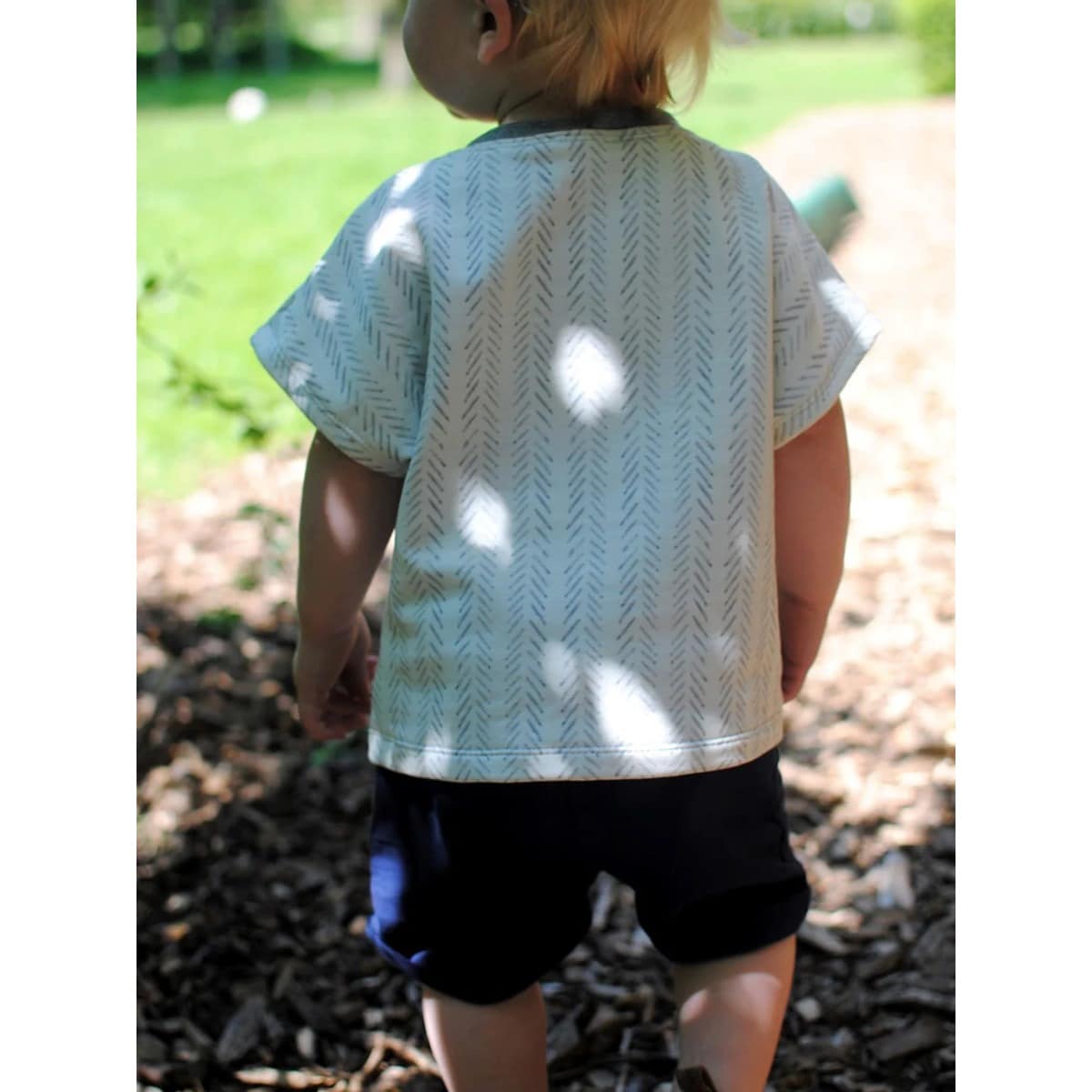 Kleinkind von hinten im hellen Family Shirt Kids mit Fischgrätmuster und gesäumten Ärmeln