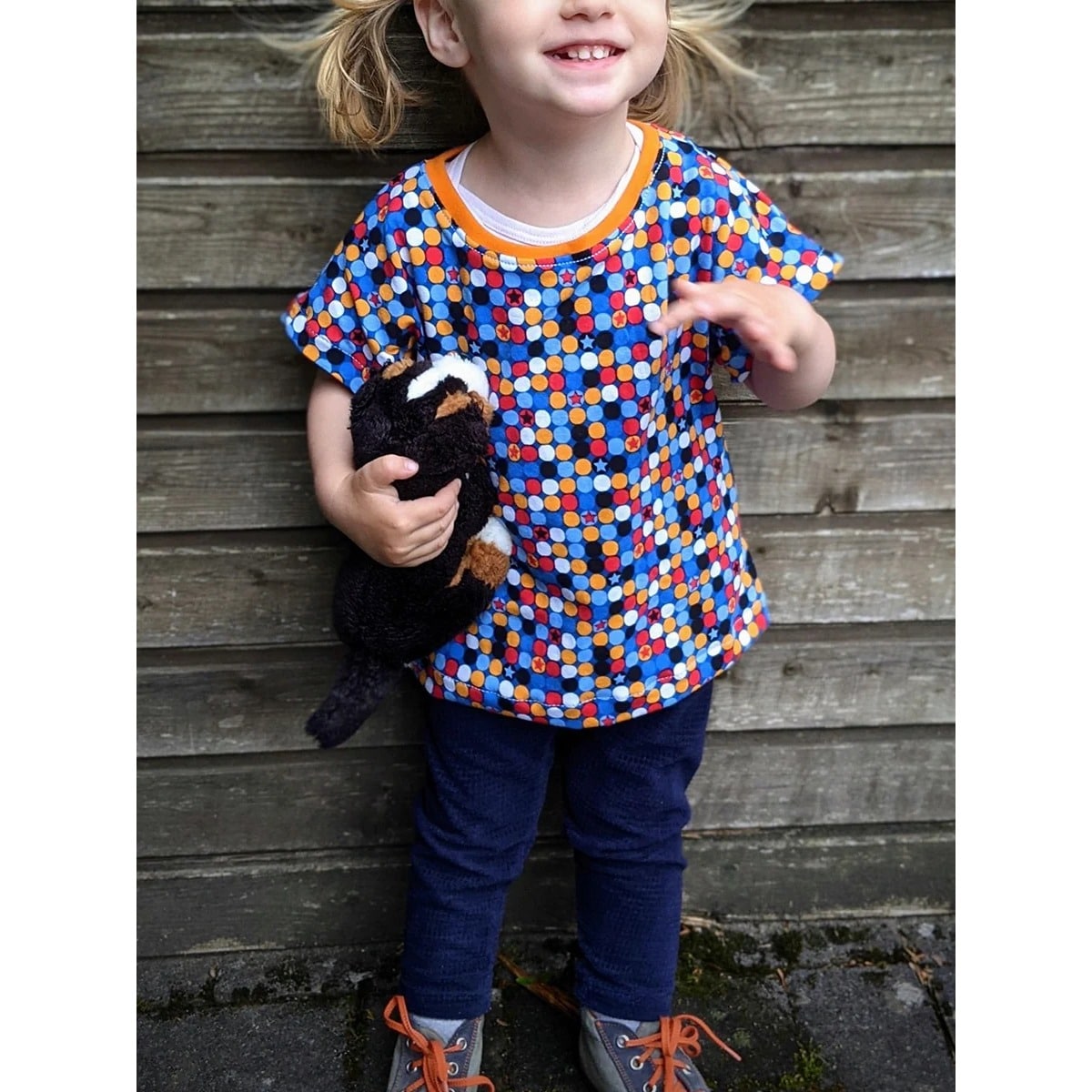 Kleinkind lacht im Family Shirt Kids aus blauem Jersey mit buntem Punkte-Muster