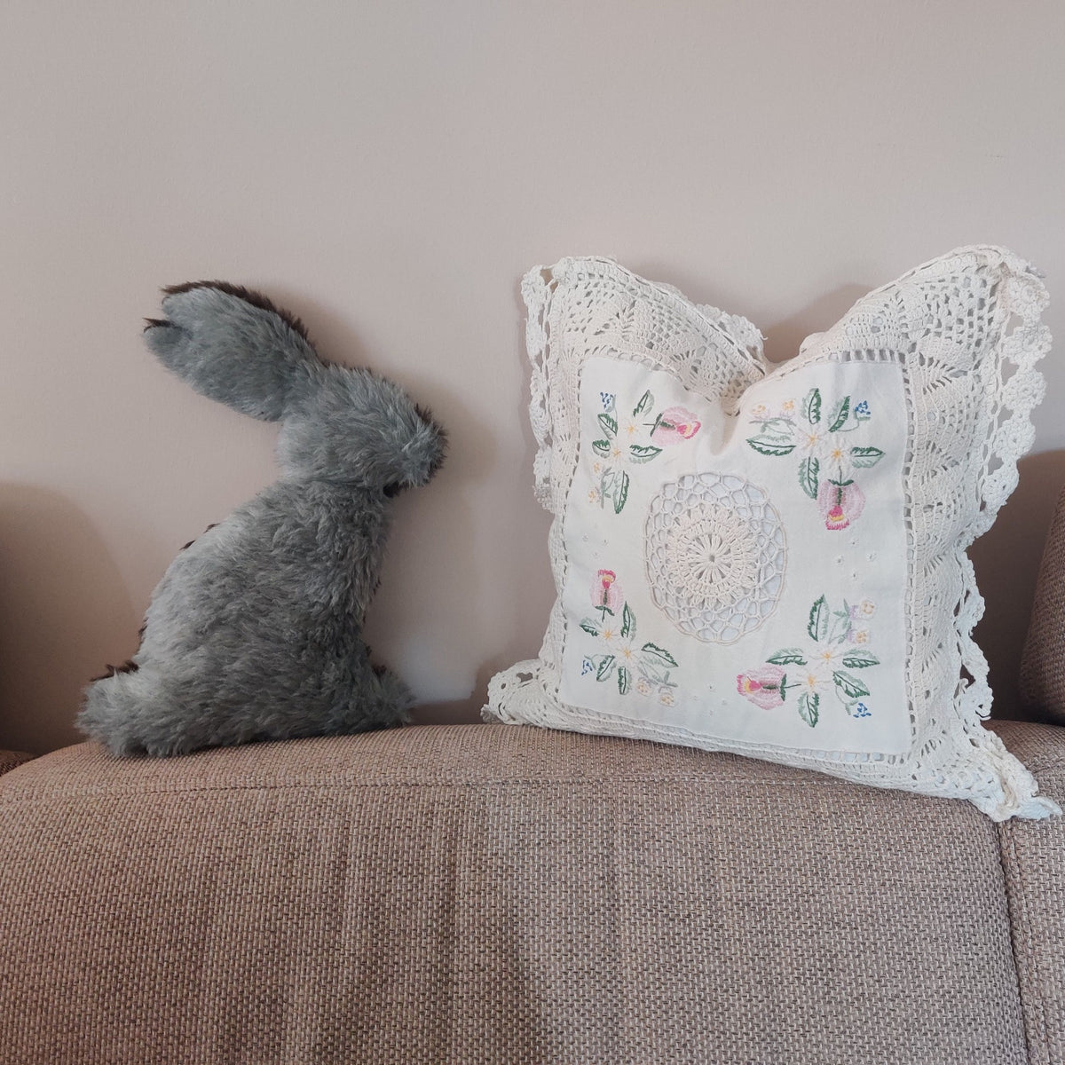 Hasensilhouette Freebie – grauer Kuschelhase neben einem Kissen mit Spitze auf dem Sofa