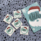 HoHoHo-Sticker neben der HoHoHo-Postkarte zum Farbvergleich