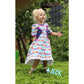 Kleid kleine Madame Schnittmuster – Mädchen im weiß-lila geblümten Kleid im Garten (genähtes Designbeispiel)