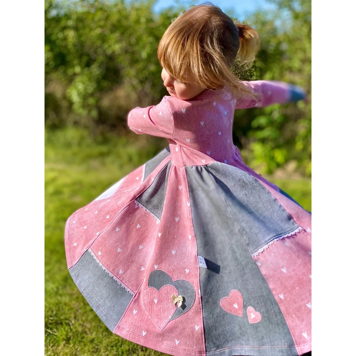 Lottis Drehkleid Schnittmuster – drehendes Kleid mit rosa Herzchen-Oberteil und grauem Jeansrock mit Herz-Applikationen