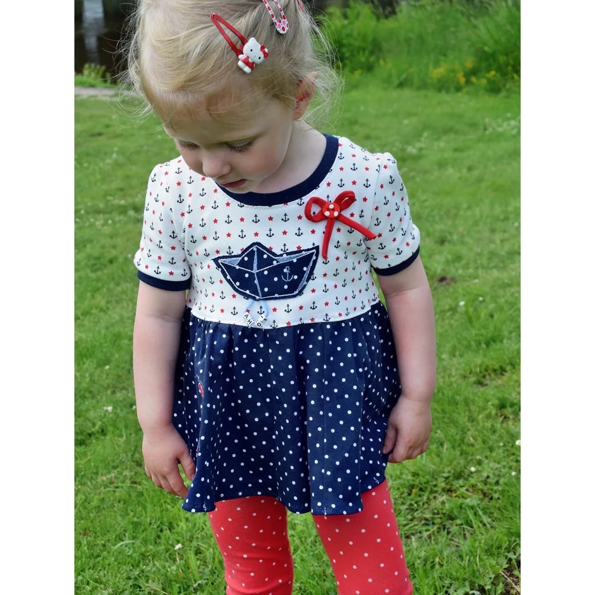 Lottis Drehkleid Schnittmuster in Tunika-Länge – maritimes Kleinkindkleid mit Anker-Print, Papierschiff-Applikation und dunkelblauem Punkterock
