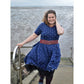 Sommerwunderkleid for me Schnittmuster – Frau im dunkelblauen Sommerwunderkleid mit rotem Gürtel am Meer (genähtes Designbeispiel)