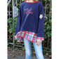 Oversized Pulli Bundle Schnittmuster – Kind im dunkelblauen Oversized-Pulli mit kariertem Saum (genähtes Designbeispiel)