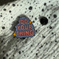 Emaille-Pin „Do your thing“ auf gepunktetem Stoff, daneben der Pin-Verschluss