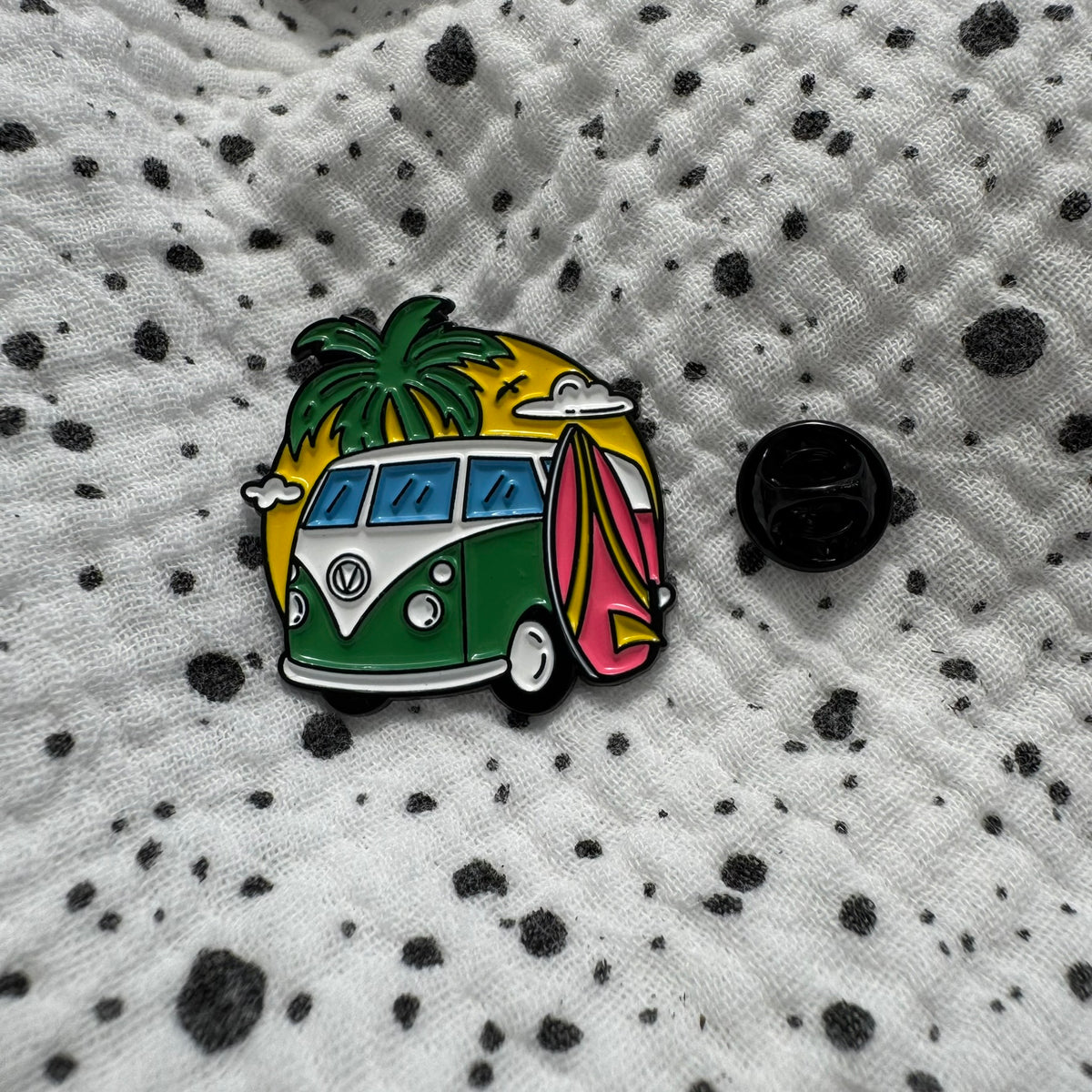 Emaille-Pin „Summer Vanlife“ auf gepunktetem Stoff, daneben der Pin-Verschluss