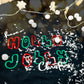 Plotterdatei Christmas Sweater – Schriftzug Holly Jolly Christmas in Grün und Rot auf dunklem Pulli (Beispiel aus der Probephase)