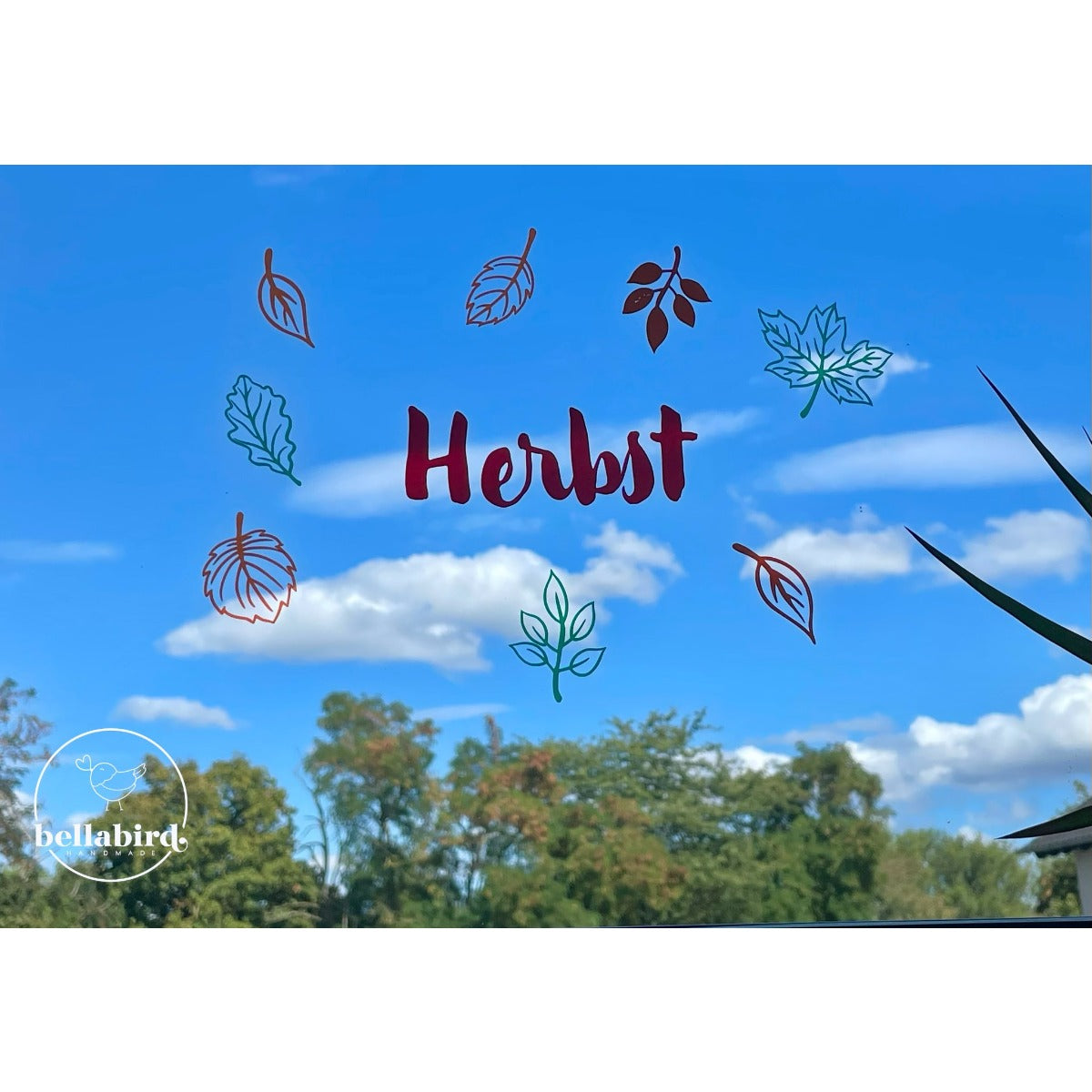 Herbstkind Plotterdatei – Schriftzug auf der Fensterscheibe, hier nur als „Herbst“ geplottet und von bunten Blättern umgeben