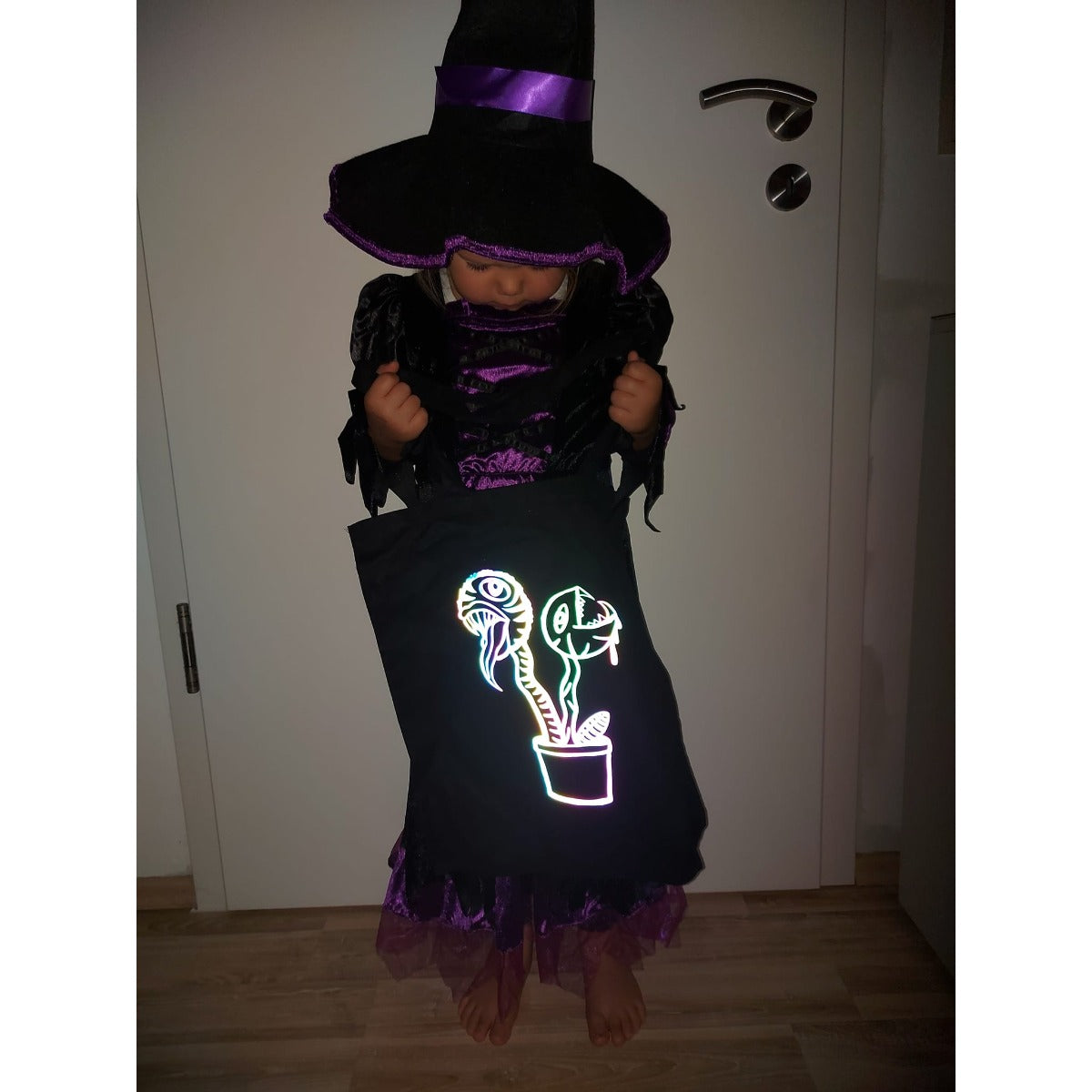Plotterdatei Lottis Halloween Pflanzen – schwarzer Stoffbeutel mit nachtleuchtendem Pflanzenmotiv, getragen von einem Kind im Hexenkostüm