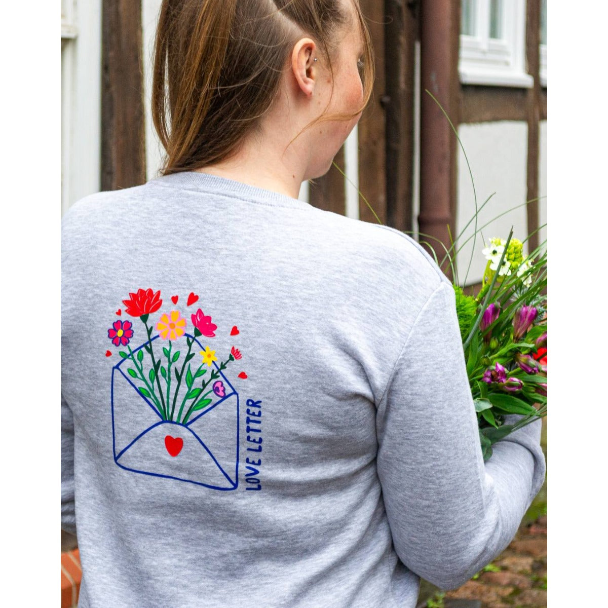 Plotterdatei Love Letters – Briefumschlag mit Blumenstrauß als Motiv auf dem Rücken eines grauen Pullis