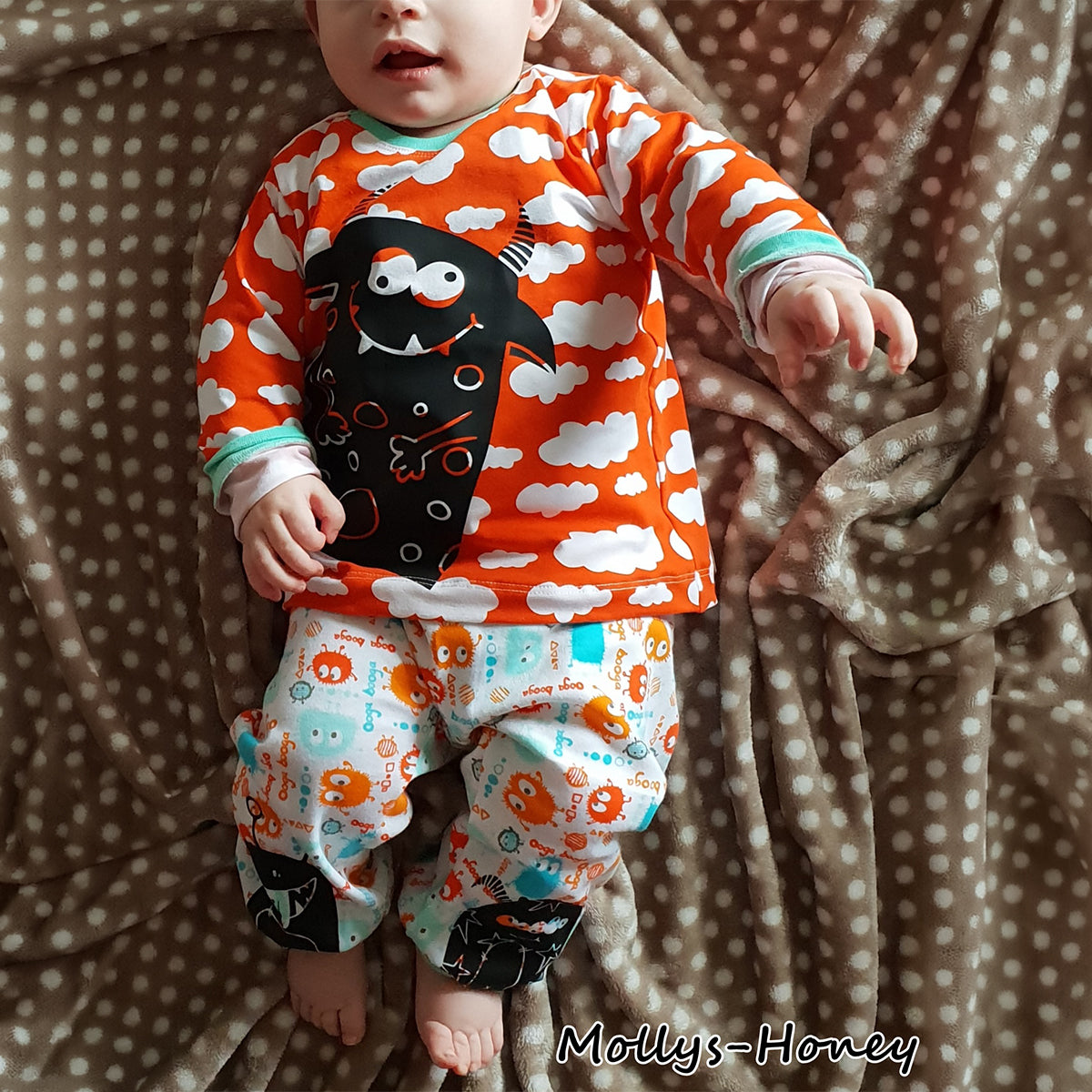 Plotterdatei Monsterbande – schwarze Monster auf Babykleidung aus orangem Wolkenstoff mit passender Pumphose