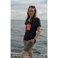 Frau im schwarzen T-Shirt am Meer mit Krebs der Plotterdatei Sea Life auf pink-orangen Streifen