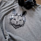 Graues Shirt mit Hasenkopf in Metallicfolie, daneben schwarze Kopfhörer