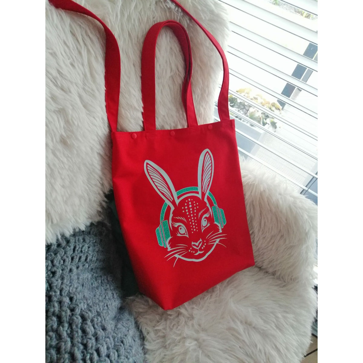 Rote Stofftasche mit Hasenkopf und türkisen Kopfhörern