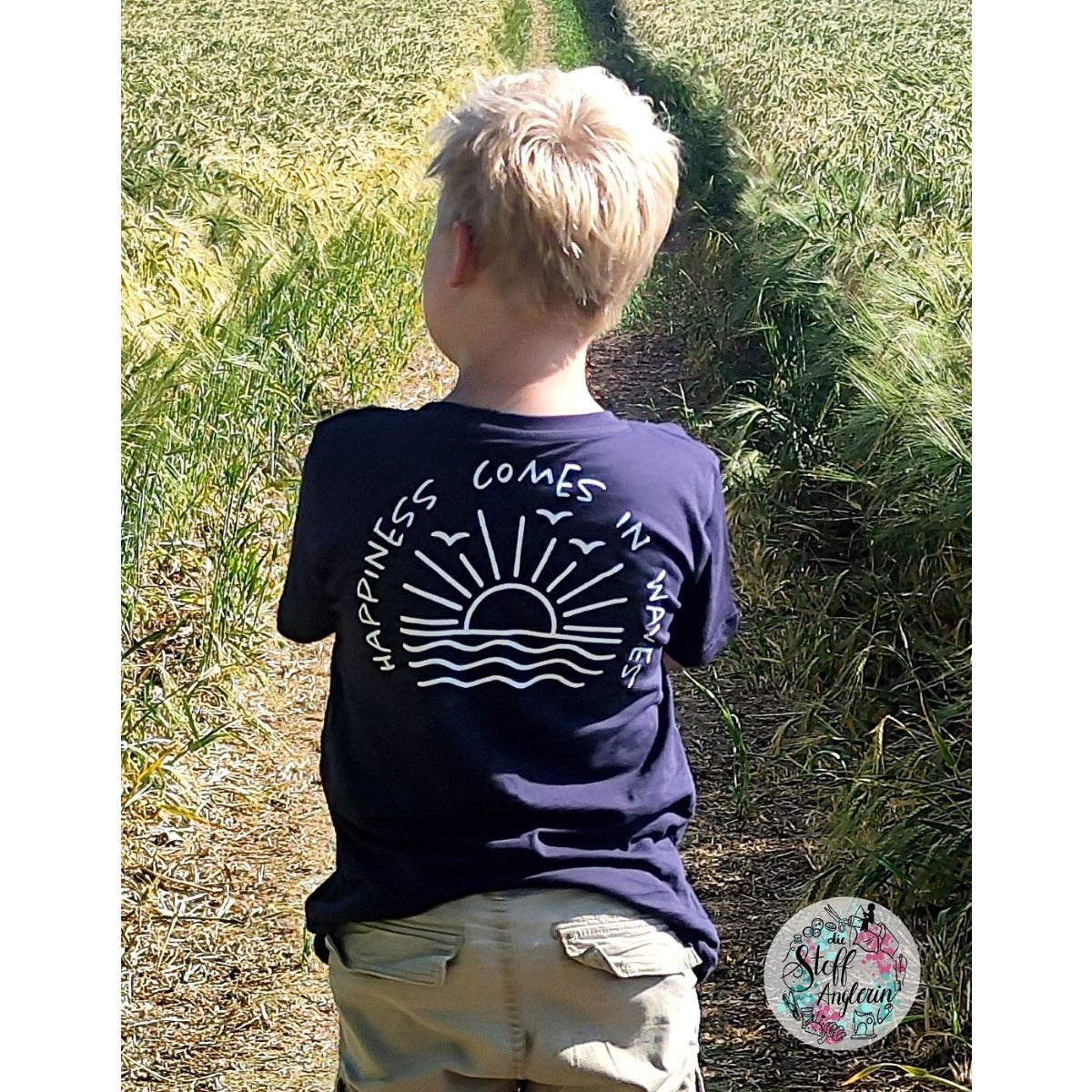 Junge von hinten im dunkelblauen Shirt mit Plotterdatei „Happiness Comes in Waves"