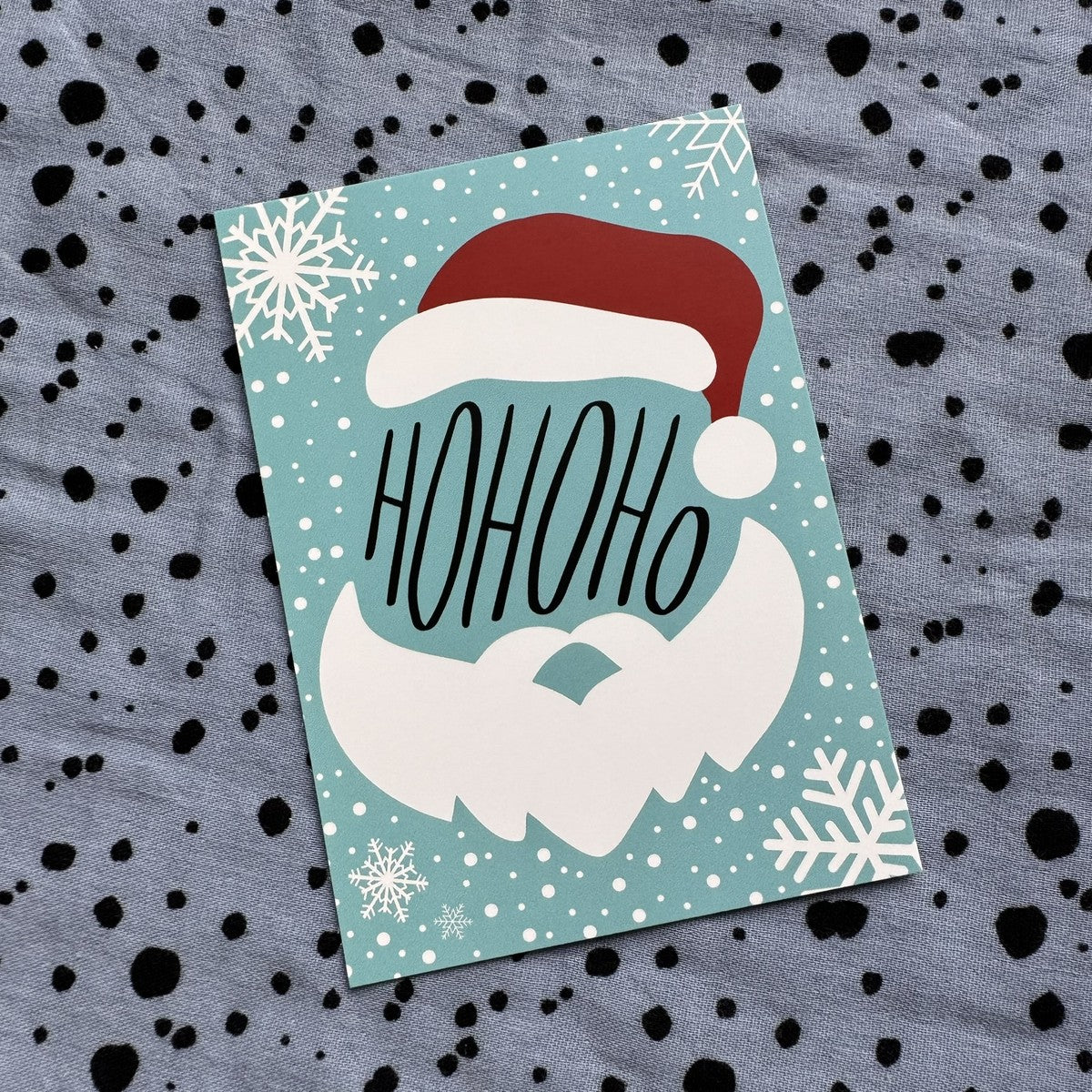 Postkarte HoHoHo mit Weihnachtsmann auf türkisem Grund mit Schneeflocken