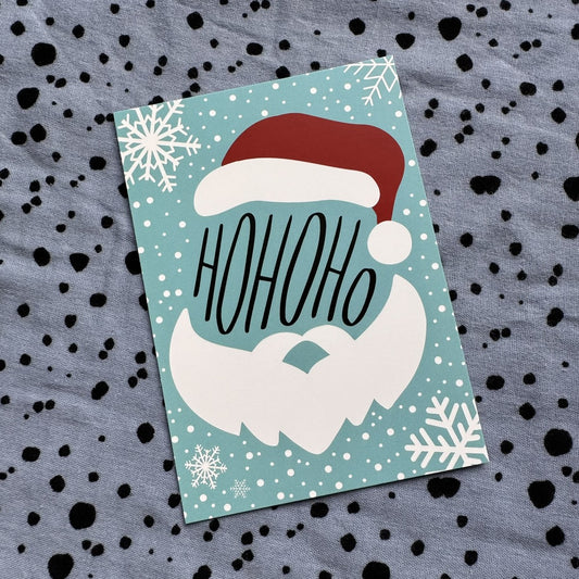 Postkarte HoHoHo mit Weihnachtsmann auf türkisem Grund mit Schneeflocken