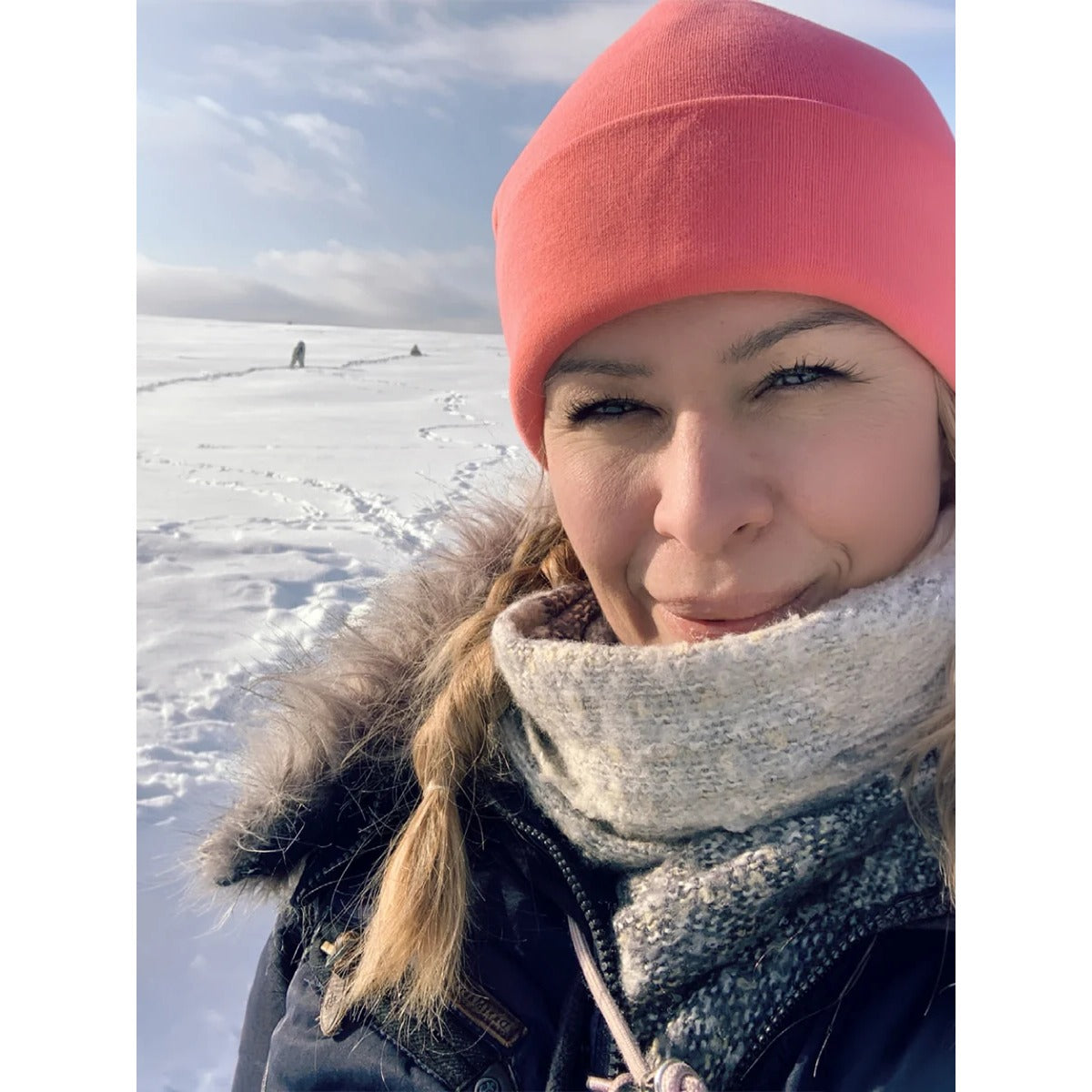 Beanie Bernie – Umschlagbeanie aus korallenfarbenem Sweatstoff, getragen von einer Frau im Schnee