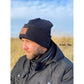 Beanie Bernie – Umschlagbeanie aus dunkelblauem Rippbündchen mit Ahoi-Kunstlederlabel, getragen von einem Mann mit Bart