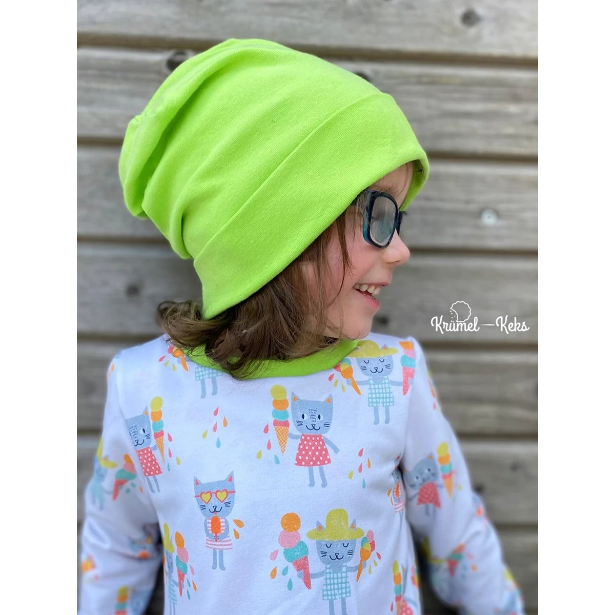 Beanie Bernie – neongrüne Umschlagbeanie, getragen von einem Mädchen im Shirt mit Eis-Katzen-Print