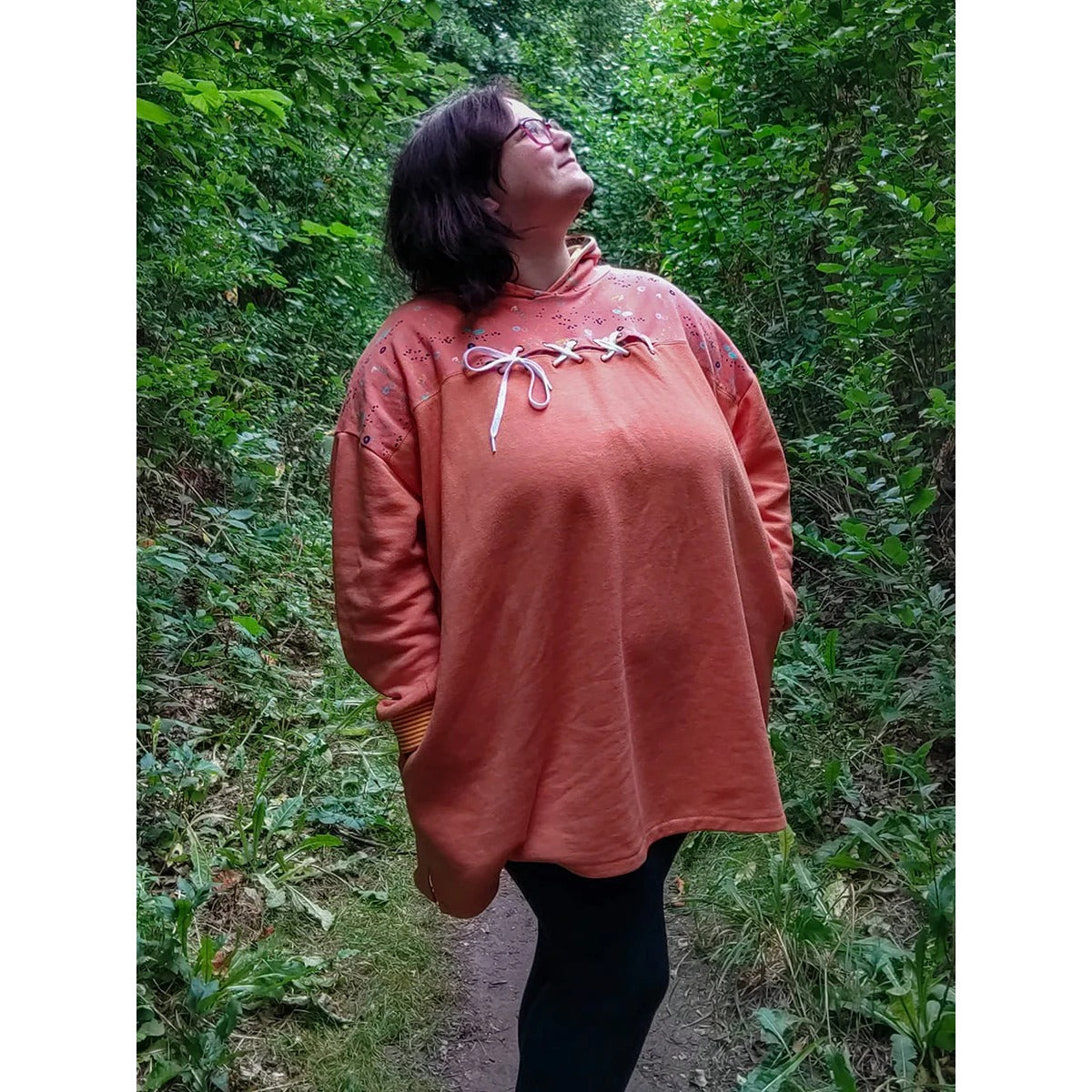 Cut Out Kleid – apricotfarbenes Kleid mit gemustertem Passenstoff und Cut-Out an der Brust mit Nieten-Schnürung