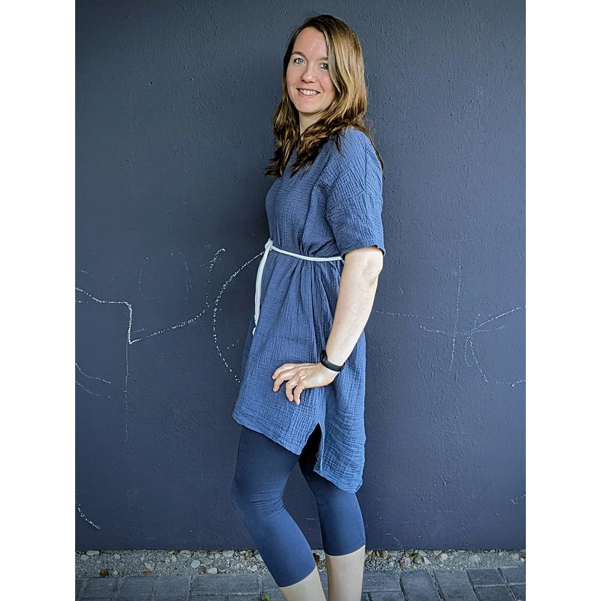 Cut Out Kleid – blaues Musselin-Kleid mit hellem Bindeband an der Taille, dazu blaue Leggings