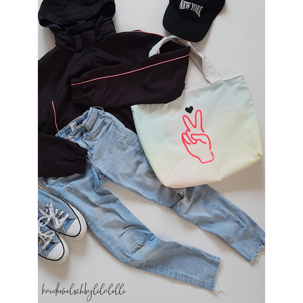 Teddy Shopper – kleine Kid Bag aus hellem Canvas mit Peace-Hand- und Herz-Plot, im Flatlay mit Jeans und Sneakern