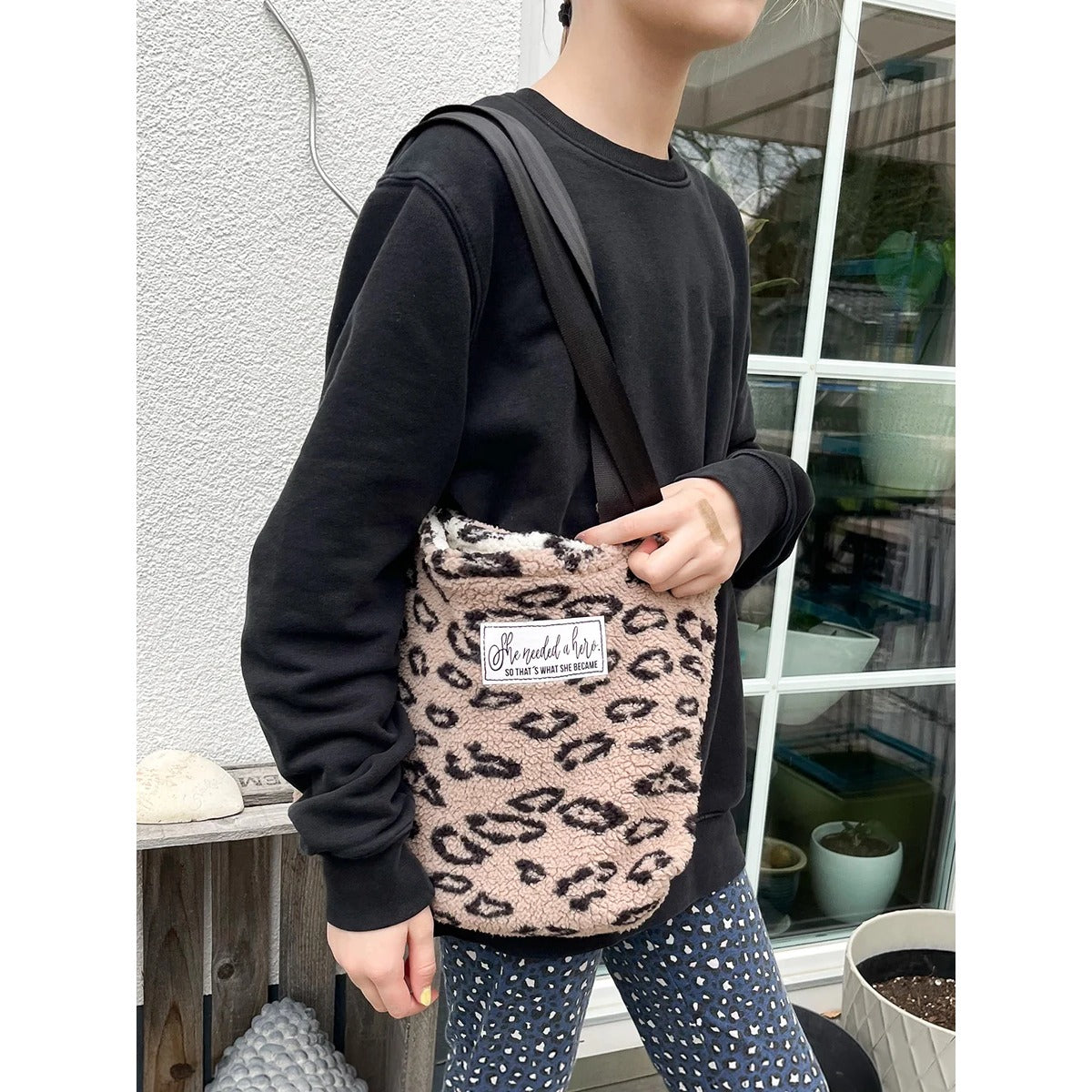 Teddy Shopper – kleine Kid Bag aus beigefarbenem Leoparden-Teddyplüsch mit ‚She needed a hero'-Label, als Crossbody getragen