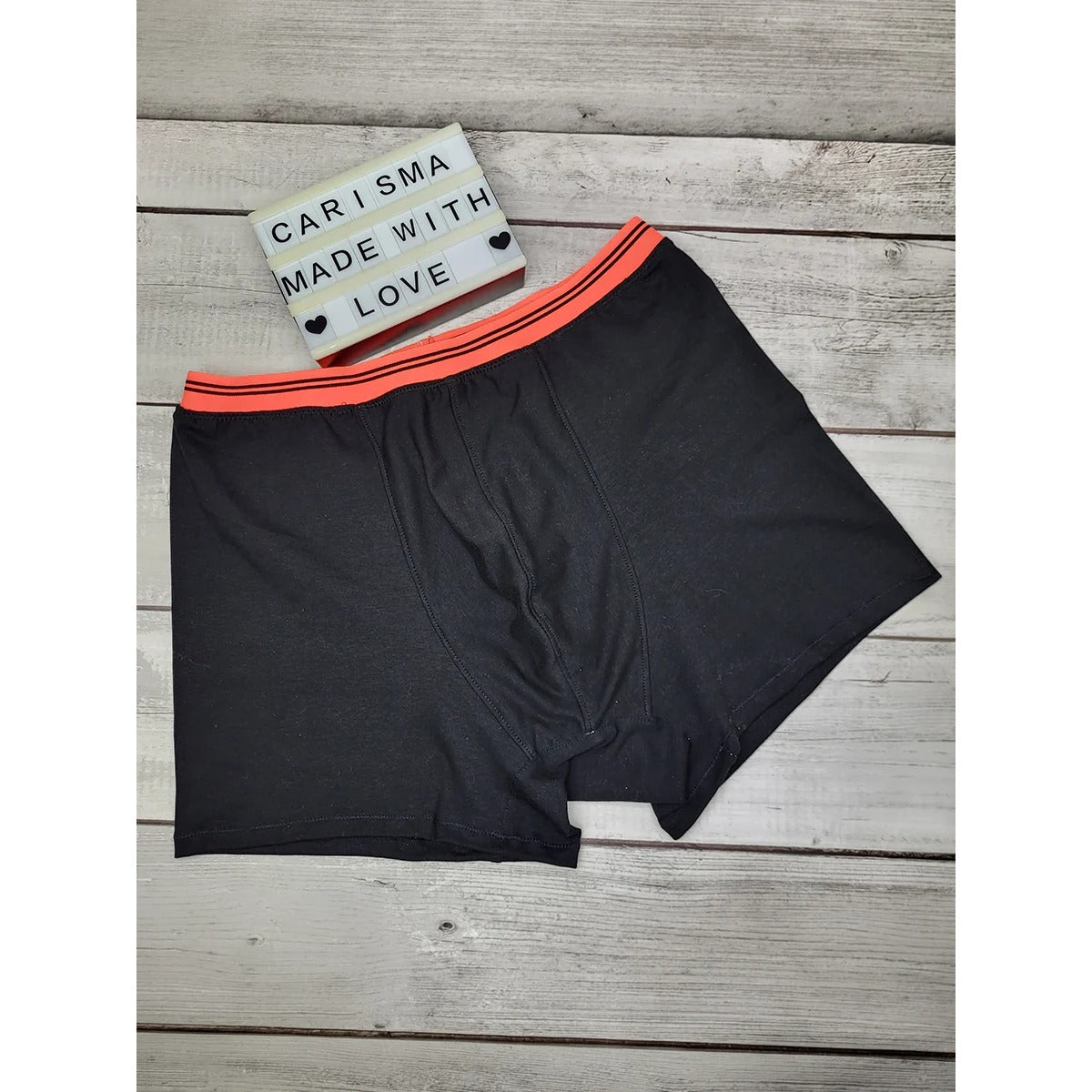 Herren Schlüppi Schnittmuster – schwarze Boxershorts mit sichtbar angenähtem, neonorange gestreiftem Gummibund