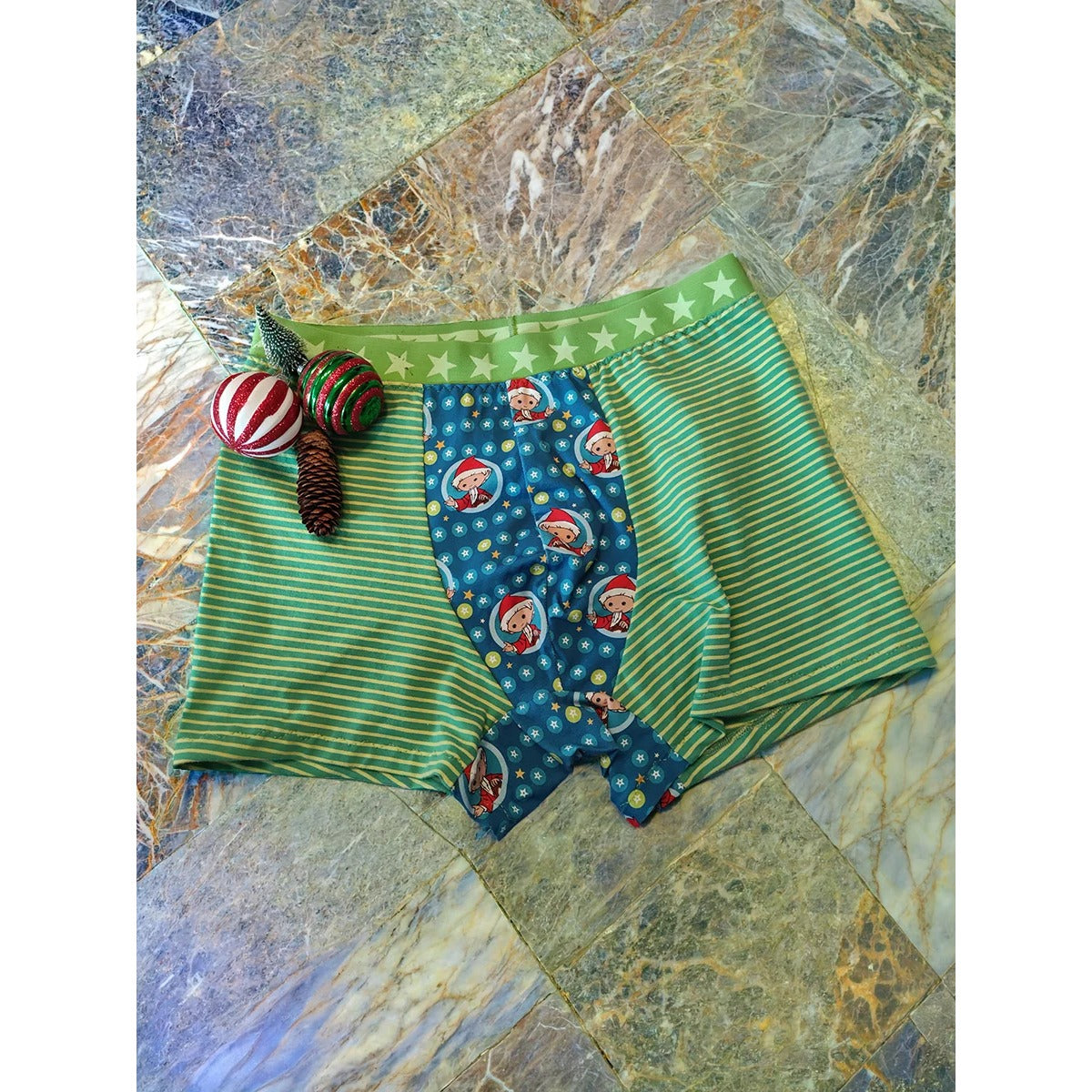Herren Schlüppi Schnittmuster – Boxershorts aus Stoffresten mit grün-gelb geringelten Seitenteilen und kontrastierendem Wichtel-Mittelteil, mit sichtbar angenähtem Gummibund im Sternenmuster