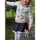 Lottchen Kinder als Hoodie aus cremefarbenem Jersey mit Mädchen-Print, rosa Bündchen und weißer Spitze am Ausschnitt, dazu Lottchen-Rock aus dunklem Jeansjersey mit Spitzenborte und rosa Schleife