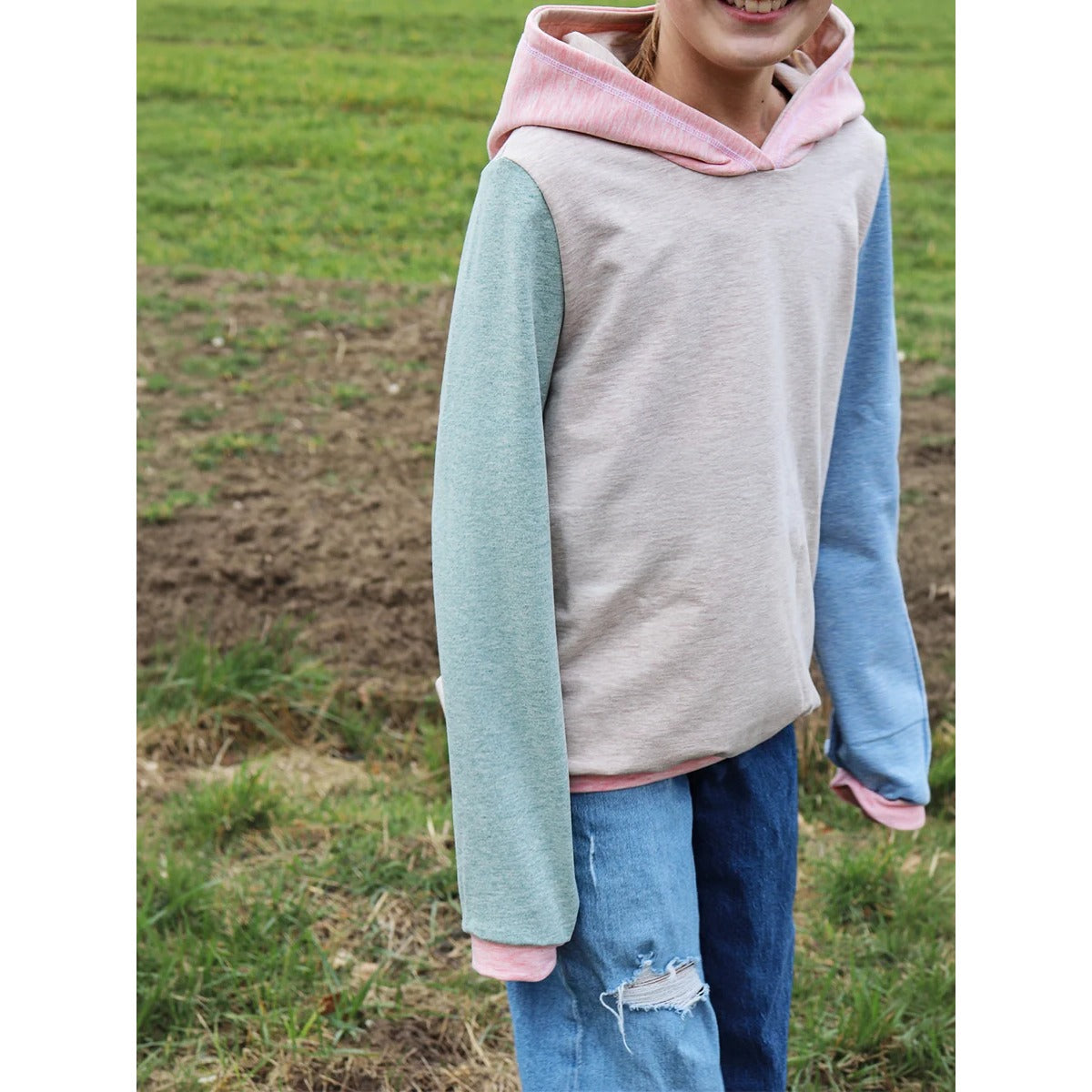 Lottchen Kinder als Hoodie im Colorblock-Stoffmix: beiges Vorderteil, ein grüner und ein blauer Ärmel, rosa Kapuze und Bündchen – ideal zur Resteverwertung