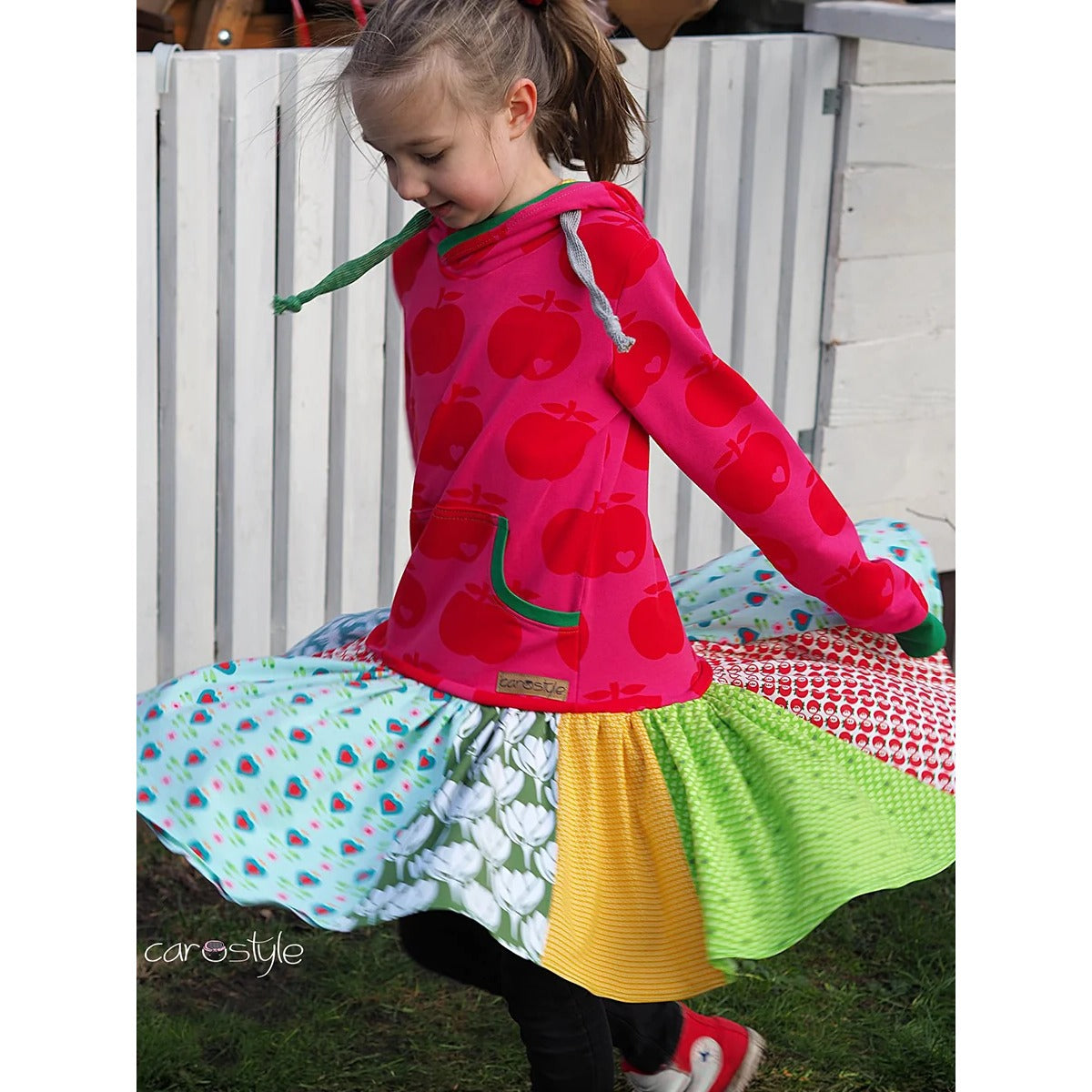 Lottchen Kinder als Hoodiekleid: Oberteil aus pinkem Apfelsweat, Rockteil aus vielen bunten Stoffstreifen im Patchwork – perfekte Resteverwertung, Mädchen dreht sich