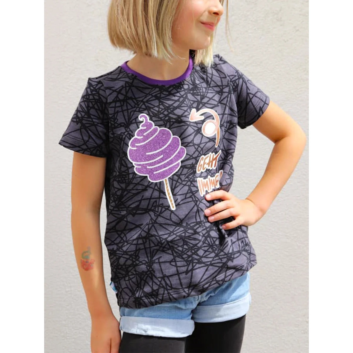 Lottchen Kinder als Shirt mit kurzen Ärmeln aus grauem Jersey mit Kritzel-Print, dazu Plotterdatei „Zuckerwatte geht immer“ in lila Glitzerfolie