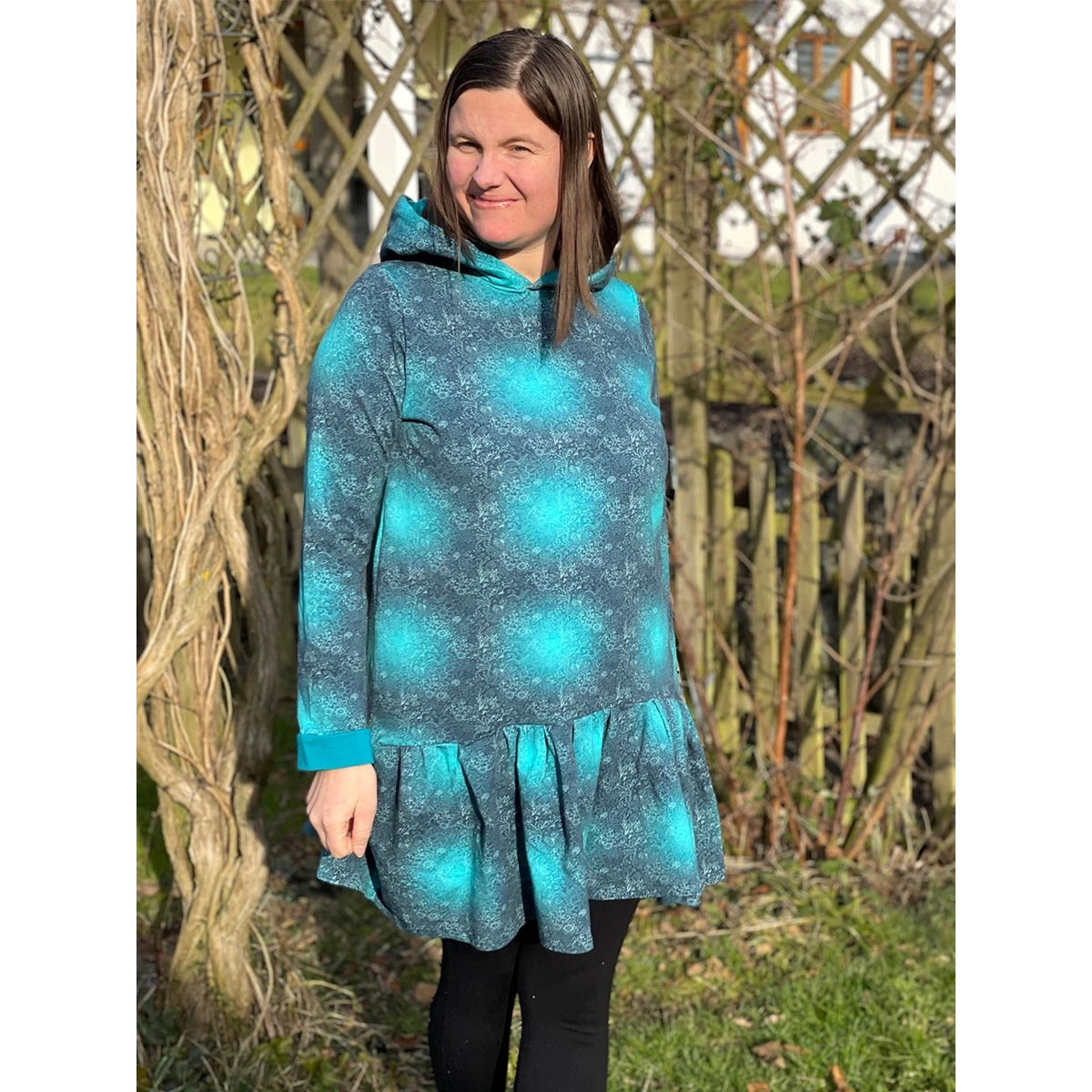 Miss Lottchen – türkis-petrolfarbenes Kleid mit Muster, Kapuze und Volant am Saum, dazu schwarze Leggings