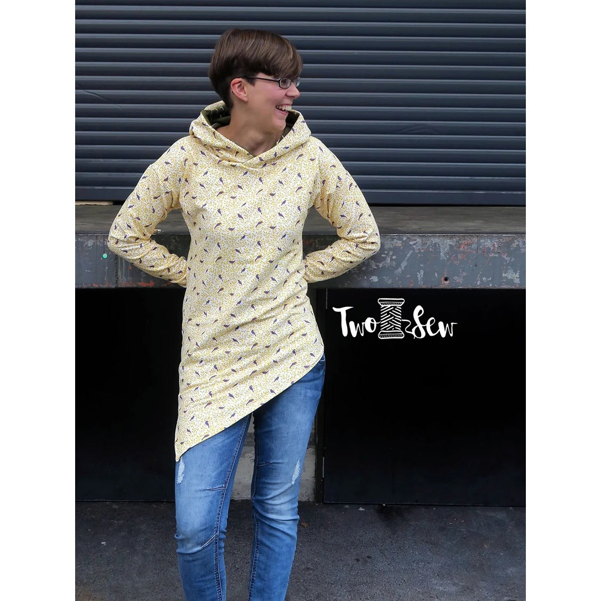 One Tip Shirt Damen als gelber Hoodie mit kleinem Vögel-Print, Langarm und Kapuze, lachende Frau mit Brille, asymmetrischer Zipfelsaum