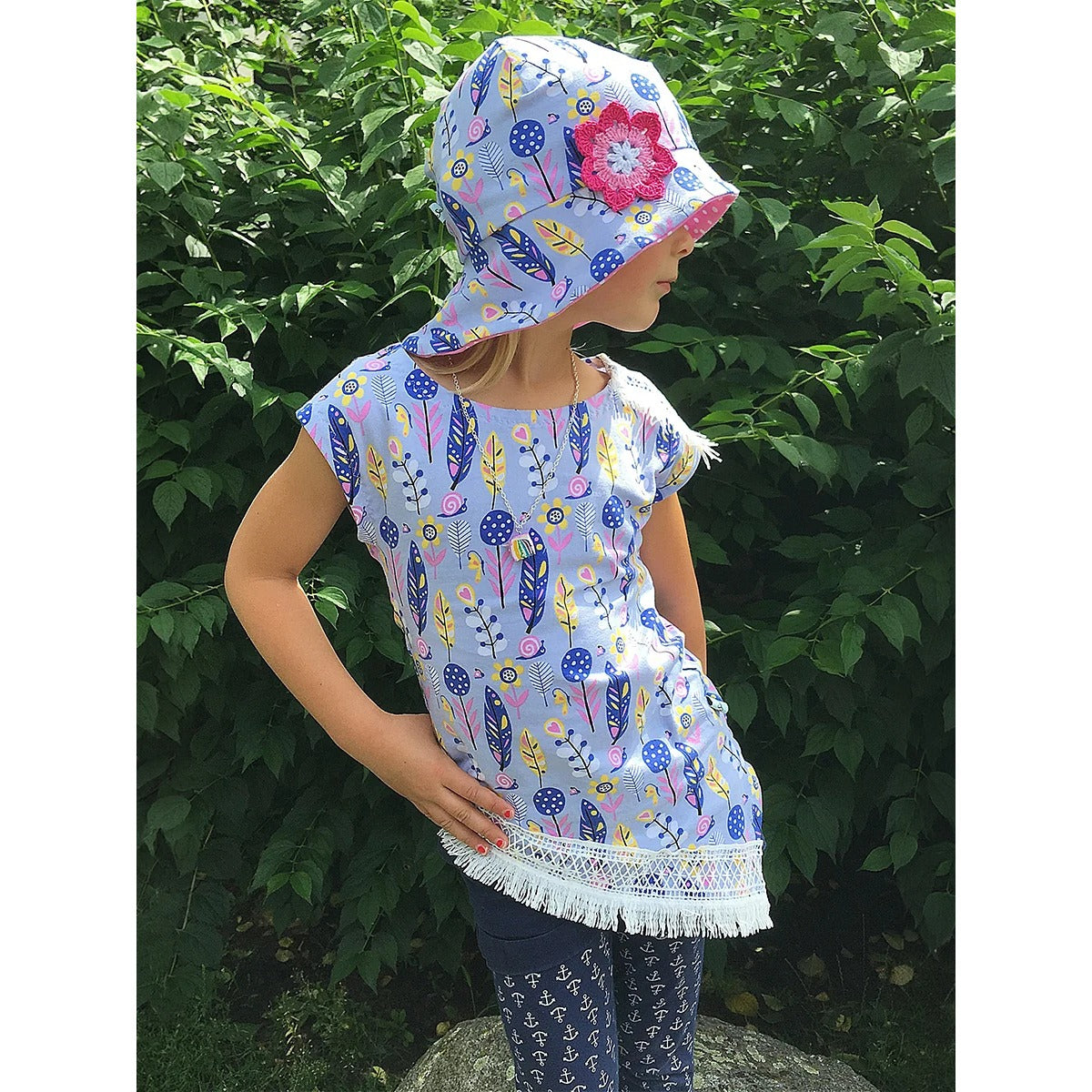 One Tip Shirt Kinder in Tunikalänge aus hellblauem Jersey mit Feder-Print, Fransenspitze am Saum und passendem Sonnenhut