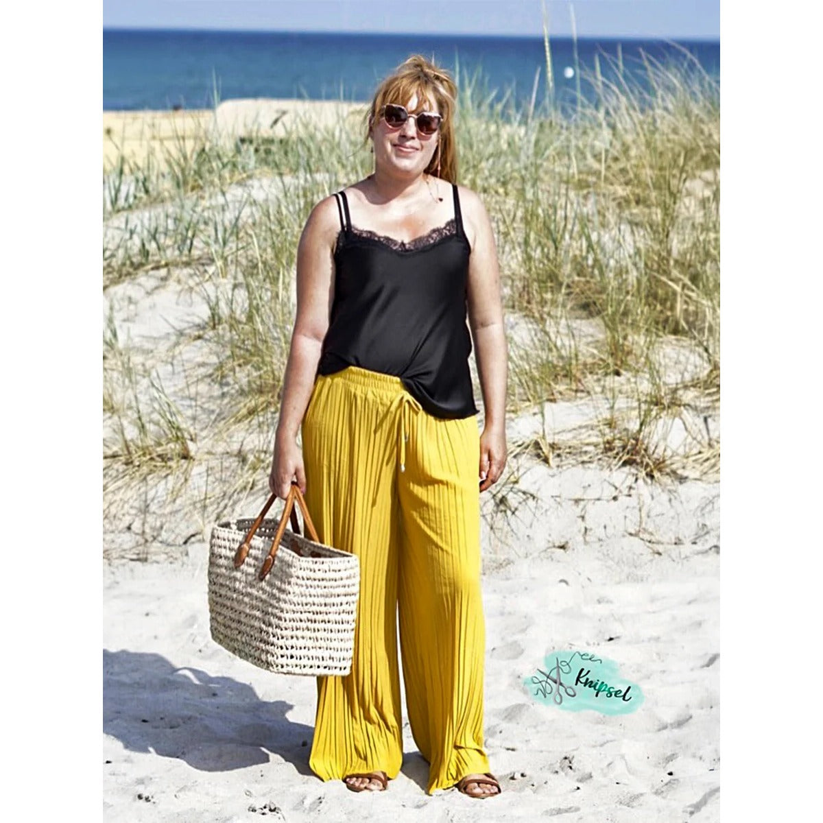Plisseehose Damen – gelbe Plisseehose mit schwarzem Spitzentop und Korbtasche
