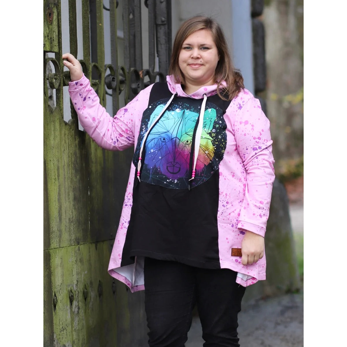 Sandras Zipfelshirt im Stoffmix: schwarzes Mittelteil mit buntem Wolf-Print, rosa Sprenkel-Seiten mit Kapuze, Langarm – Stoffreste kombiniert