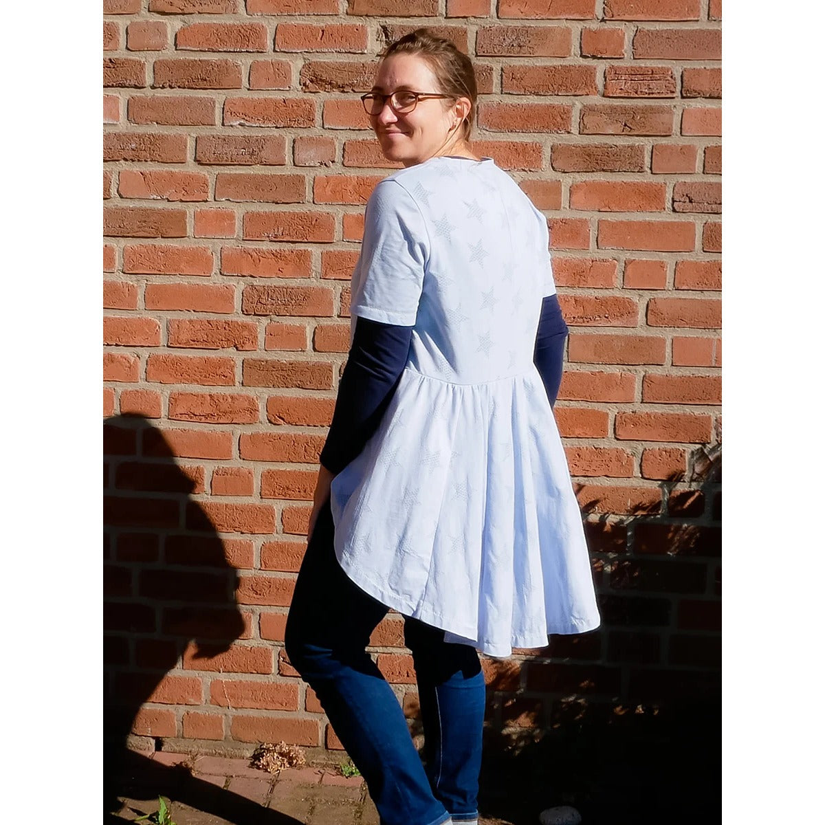 Schößchenshirt Emmelie – weißes Shirt mit dezenten Sternen und kurzen Ärmeln, über einem Langarmshirt getragen, Rückansicht