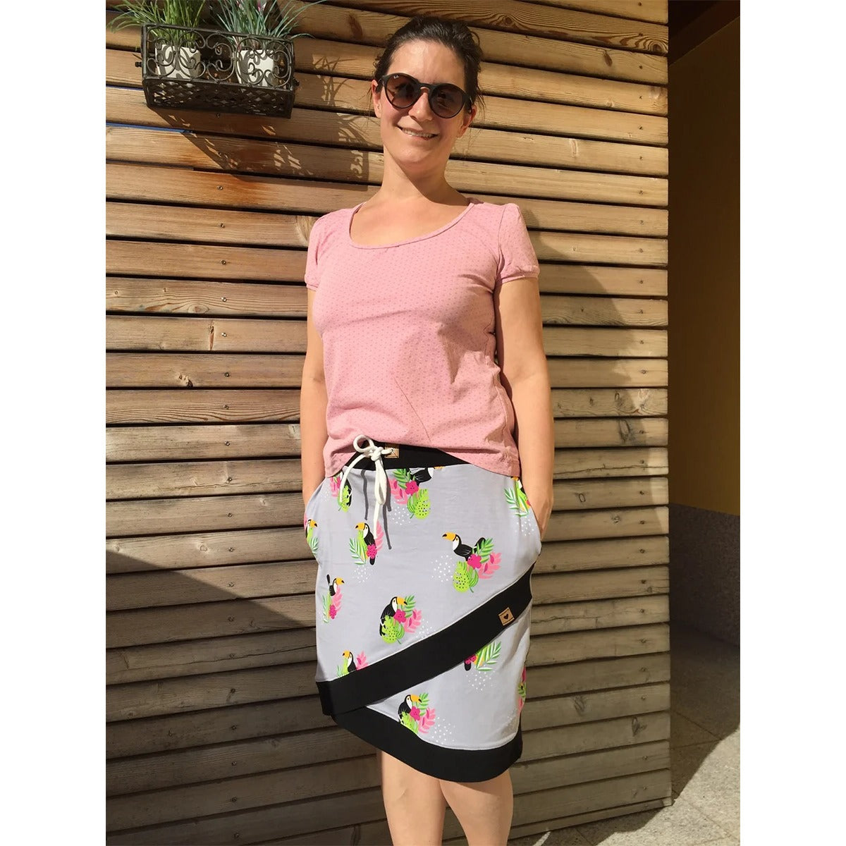 Schnittmuster Shabby Skirt Damen – grauer Jersey mit tropischem Tukan-Print und schwarzem Bündchen als diagonaler Saumabschluss, dazu rosa Shirt