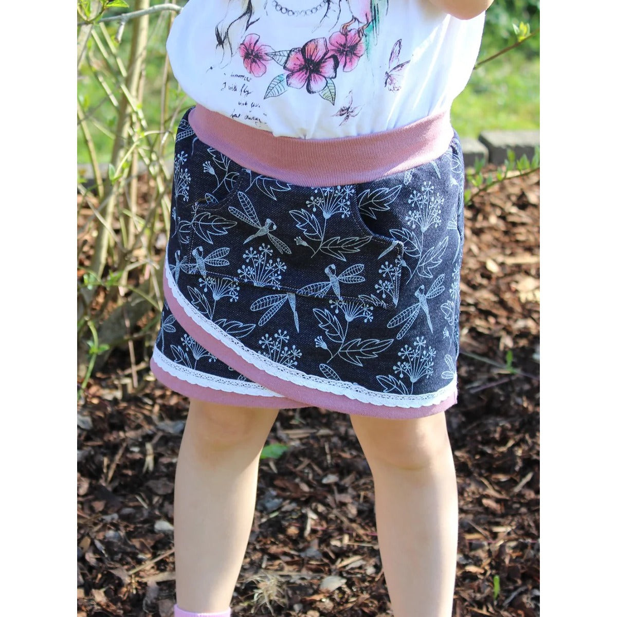 Schnittmuster Shabby Skirt Kids – dunkler Jeansjersey mit Blüten- und Libellen-Print, altrosa Bündchen und weißer Spitze eingefasst, mit Bauchtasche