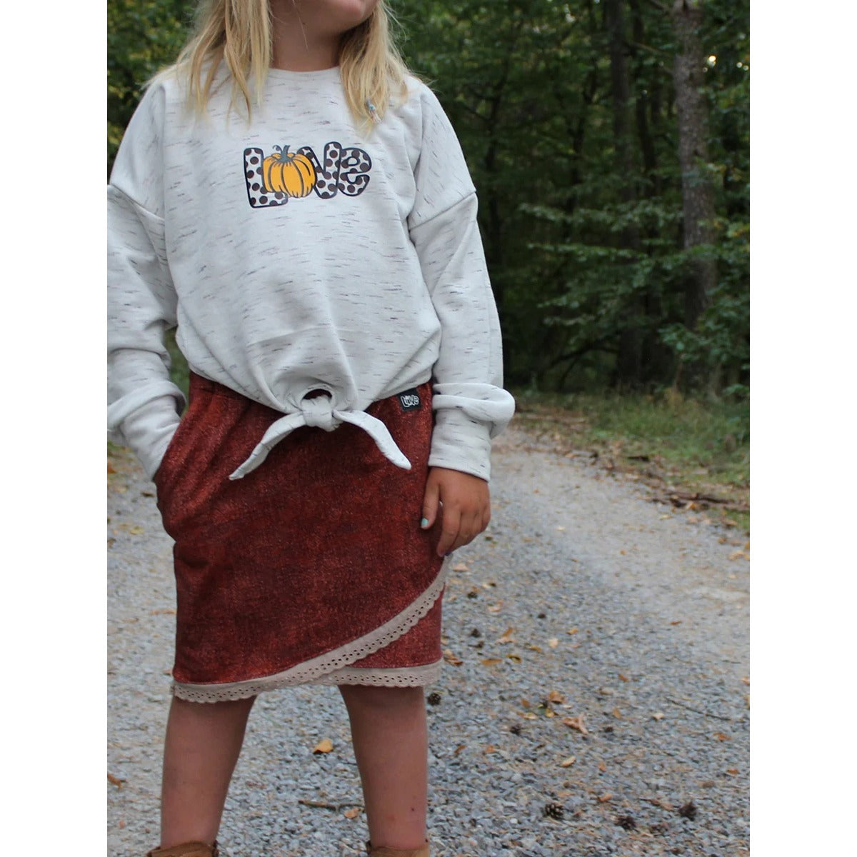 Schnittmuster Shabby Skirt Kids – rostroter Melange-Sweat im asymmetrischen Lagenlook mit cremefarbener Häkelspitze am Saum und seitlicher Eingrifftasche, dazu hellgrauer Sweater mit Plotter-Print „Kürbisliebe“