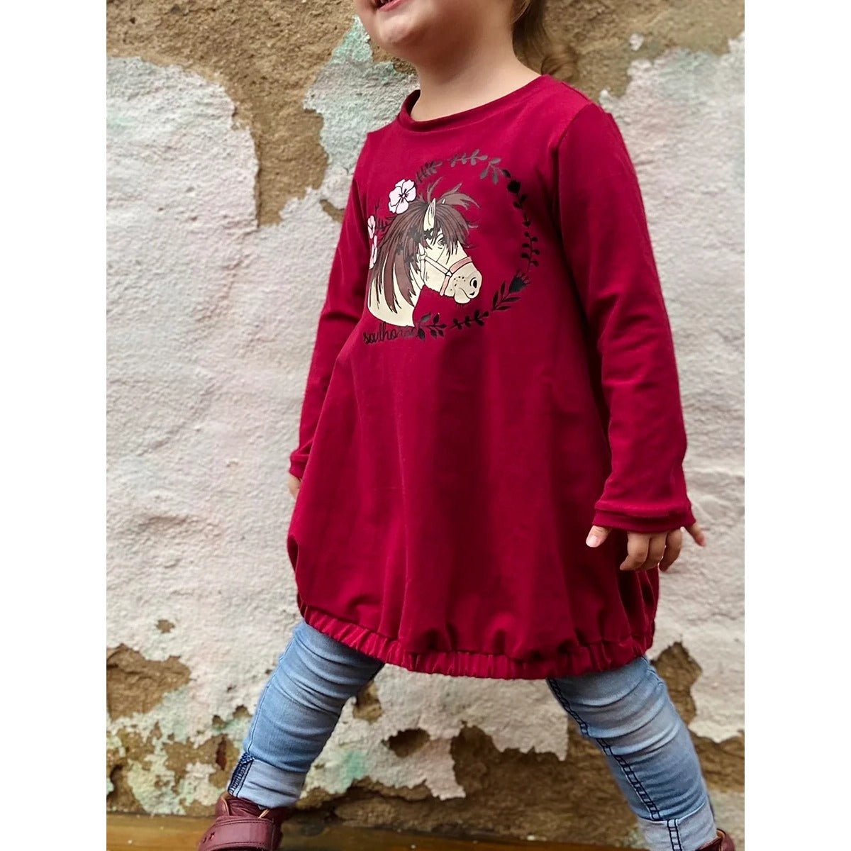 Sidecut Kleid Schnittmuster – bordeauxrote Ballontunika mit Pferdemotiv, kombiniert mit Jeans, für Mädchen
