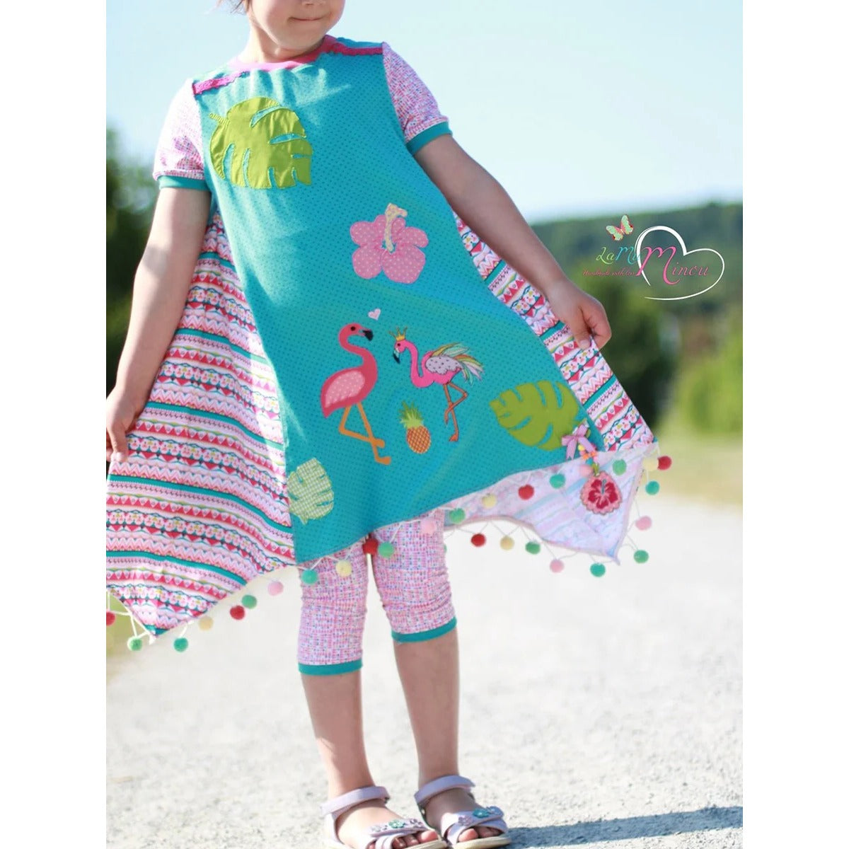 Sidecut Kleid Schnittmuster – türkises Kleid mit tropischen Applikationen (Flamingo, Hibiskus, Monstera), Zipfelsaum und bunter Bommelborte