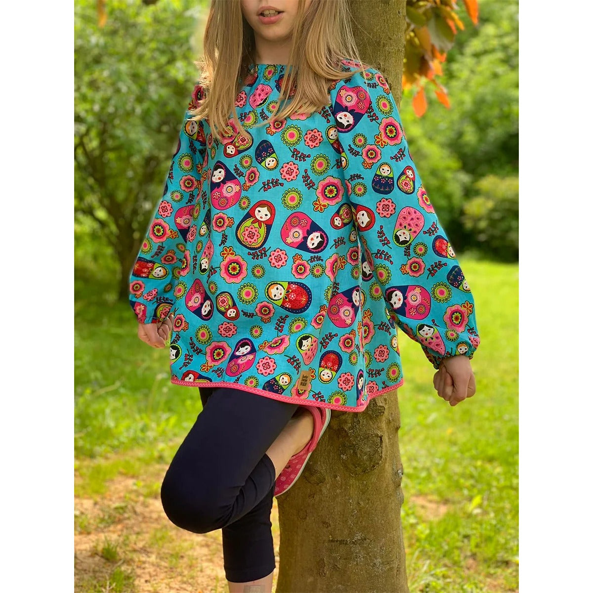 Schnittmuster Talia – türkise Tunika mit Matroschka- und Blumen-Print und langen Ärmeln mit Gummibündchen