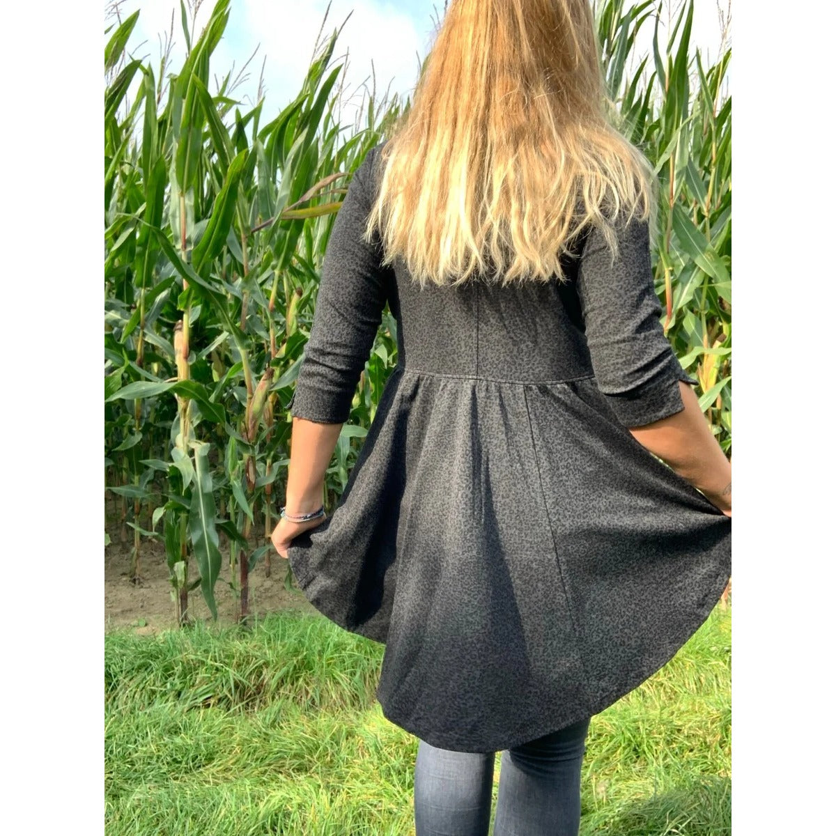 Schößchenshirt Emmelie Schnittmuster – Frau im dunkelgrauen Schößchenshirt, Rückansicht im Maisfeld (genähtes Designbeispiel)